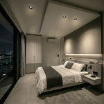 Black round ceiling downlights installed in a modern bedroom with false ceiling design