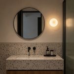 Lysa glass ball wall sconce beside bathroom vanity mirror