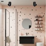 Black rotatable LED ceiling spotlight installed in modern bathroom, surface-mounted adjustable spotlight for focused task lighting