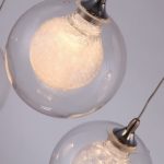 Aura Glass Ball pendant light close up with warm glowing textured inner bulb