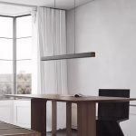 Modern black linear pendant light above dining table
