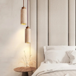 Modern pendant lamp beside bed with warm glow and natural stone finish