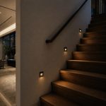 Black LED step lights installed on indoor staircase wall with warm white glow