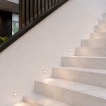 White LED step lights recessed into marble indoor staircase wall