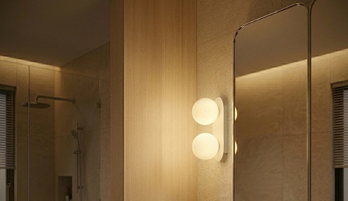 Wall lamp beside vanity mirror in modern bathroom